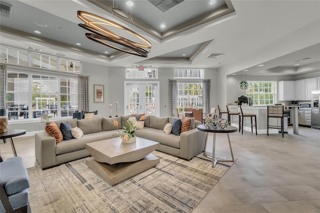 living room with french doors, a raised ceiling, visible vents, and an inviting chandelier