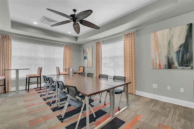 dining area with a wealth of natural light, a raised ceiling, visible vents, and baseboards