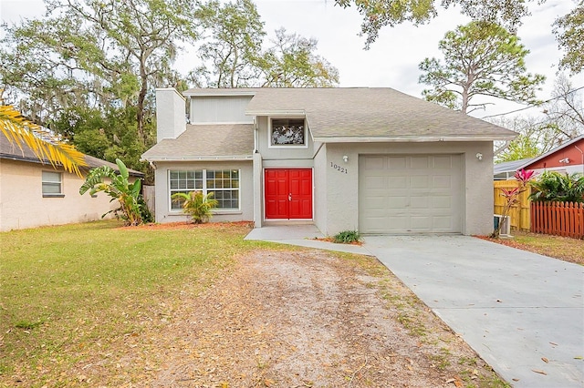 view of front facade with concrete driveway, a chimney, an attached garage, fence, and a front yard