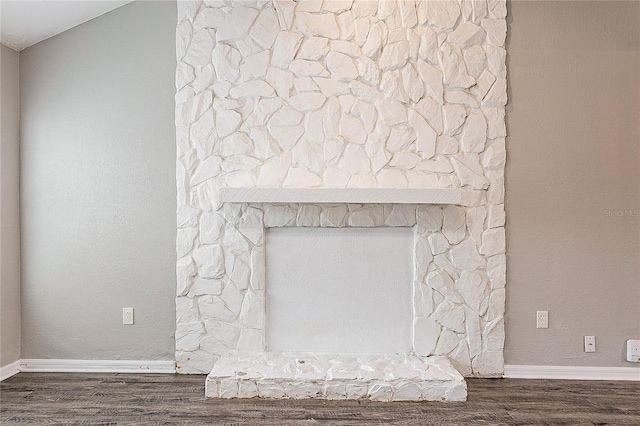 details featuring a fireplace, baseboards, and wood finished floors