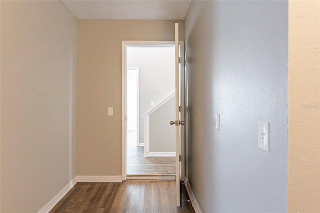 hall with dark wood-style floors and baseboards