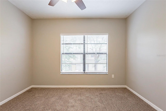 carpeted empty room with ceiling fan and baseboards