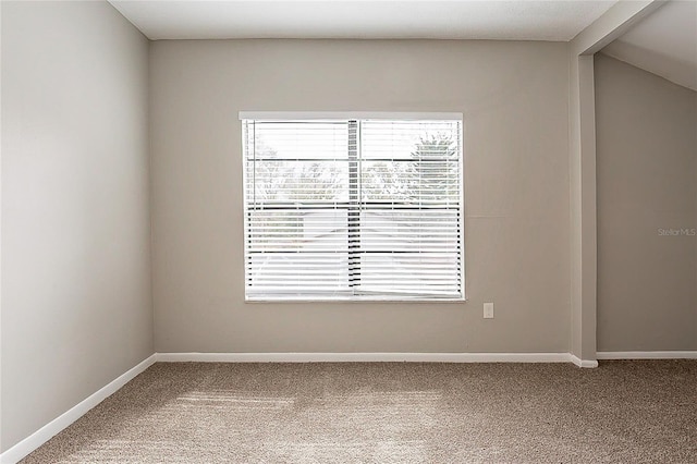 empty room featuring carpet flooring, vaulted ceiling with beams, and baseboards