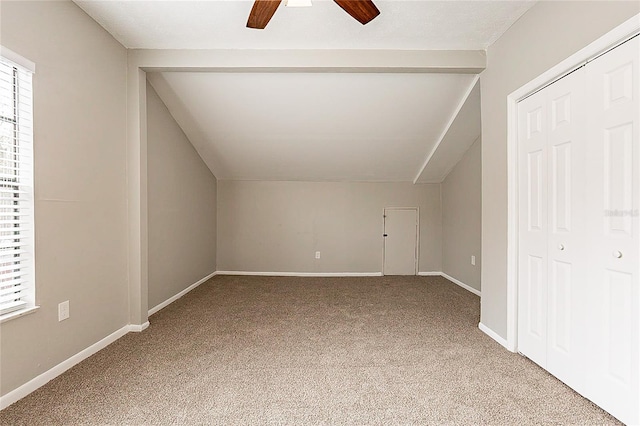 additional living space featuring plenty of natural light, light carpet, vaulted ceiling, and baseboards