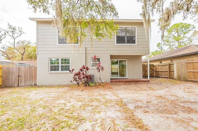 rear view of property with a fenced backyard and stucco siding