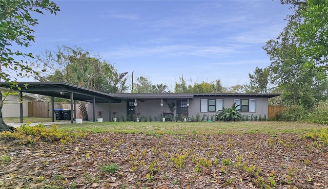 rear view of house with a yard and a carport