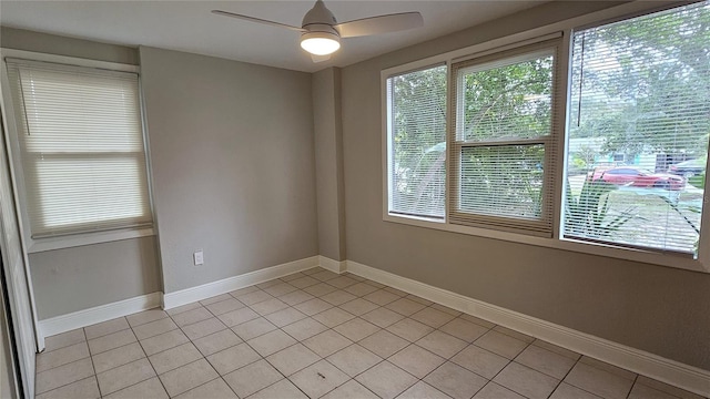 tiled spare room with ceiling fan and a wealth of natural light