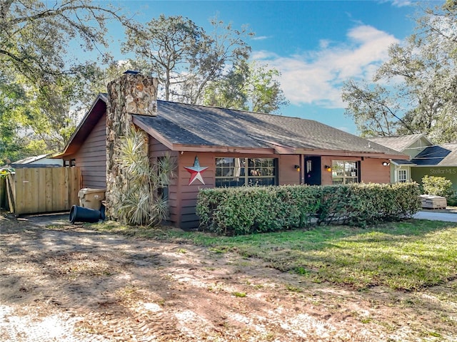 single story home with a chimney, fence, and a front yard