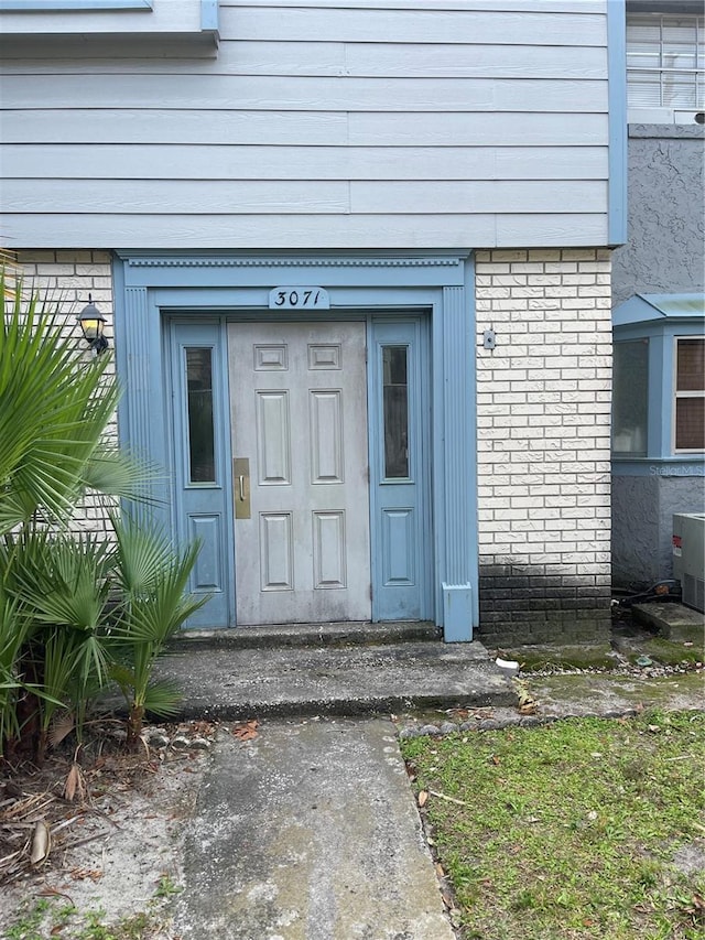 doorway to property featuring brick siding