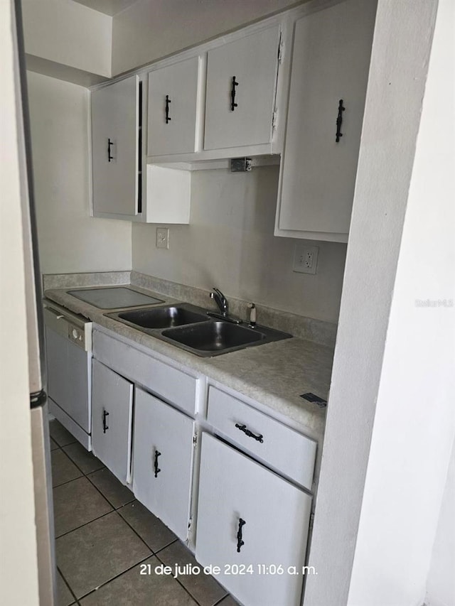 kitchen with white cabinetry, light countertops, a sink, and dark tile patterned flooring