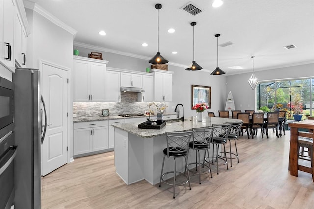 kitchen with white cabinets, visible vents, stainless steel appliances, and a sink