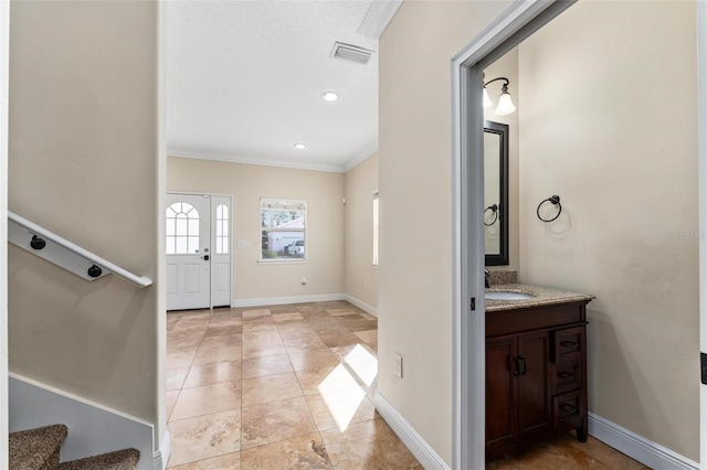 foyer entrance featuring stairway, baseboards, visible vents, and ornamental molding