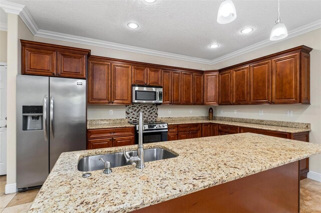 kitchen featuring light stone counters, decorative light fixtures, crown molding, appliances with stainless steel finishes, and a sink