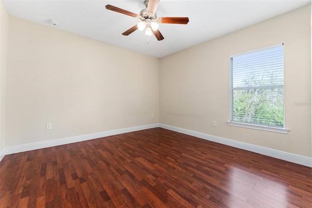 empty room featuring dark wood finished floors, baseboards, and ceiling fan