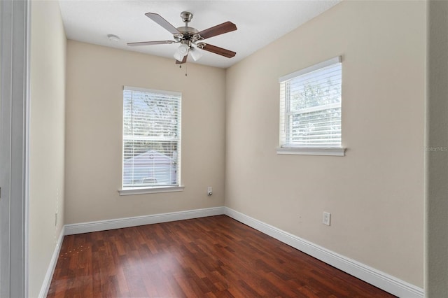 spare room with dark wood-type flooring, baseboards, and a ceiling fan