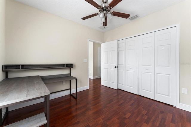 unfurnished bedroom featuring a ceiling fan, visible vents, baseboards, and wood finished floors