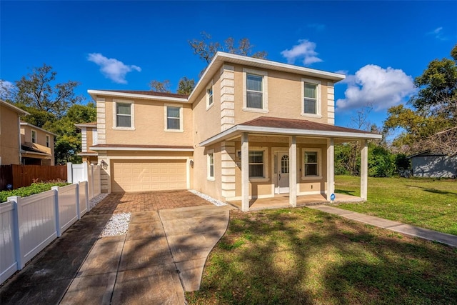 traditional-style home featuring stucco siding, concrete driveway, a front yard, fence, and a garage