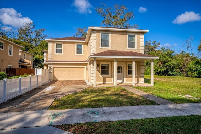 view of front of house with stucco siding, fence, a garage, driveway, and a front lawn