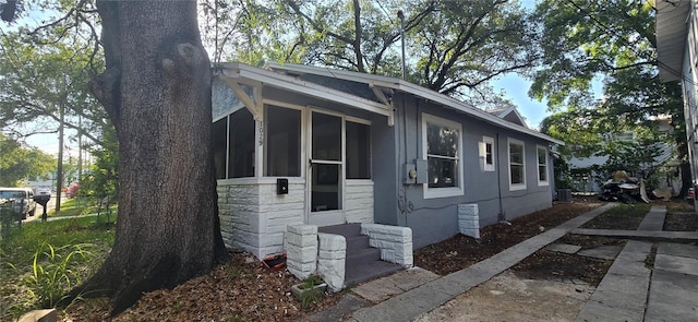 view of home's exterior with a sunroom and fence