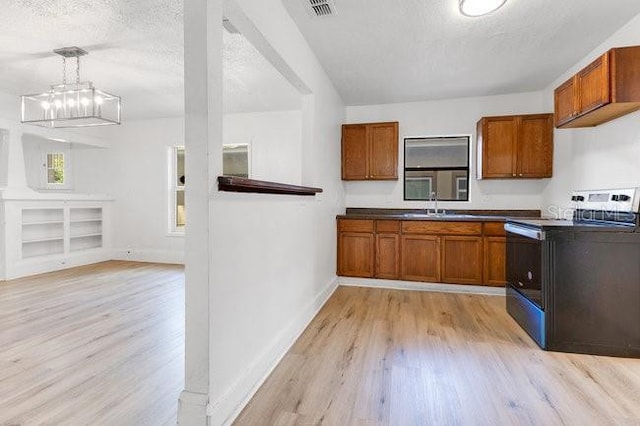 kitchen with light wood-style flooring, brown cabinetry, dark countertops, electric range, and a textured ceiling