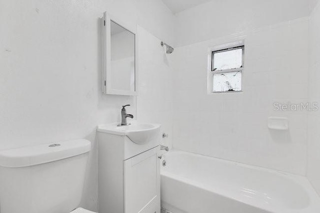 bathroom with bathing tub / shower combination, toilet, and vanity