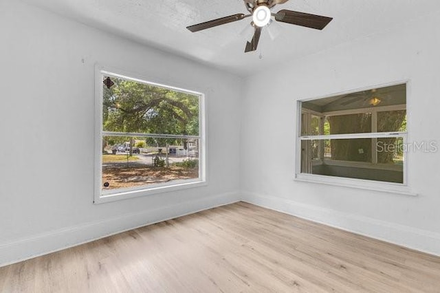 spare room with baseboards, wood finished floors, and ceiling fan