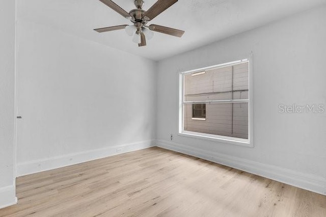spare room featuring wood finished floors, baseboards, and a ceiling fan