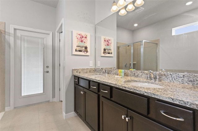 bathroom with tile patterned floors, a shower with shower door, and vanity