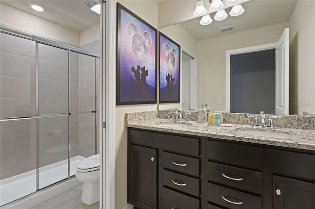 bathroom featuring vanity, toilet, and a shower with door