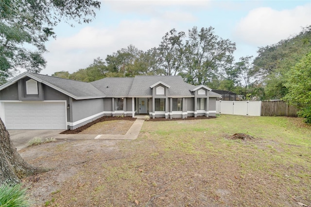 view of front of property featuring an attached garage, a front yard, fence, a gate, and driveway