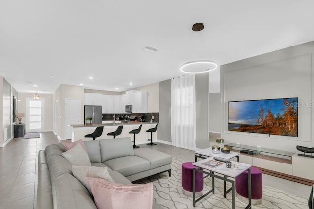 living room featuring light tile patterned floors, baseboards, and recessed lighting