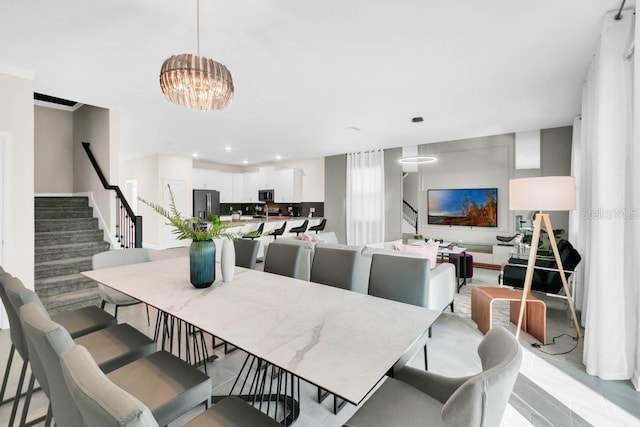 dining space featuring recessed lighting, a notable chandelier, and stairway