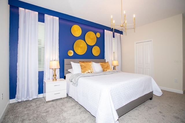 bedroom featuring a closet, baseboards, a notable chandelier, and light colored carpet