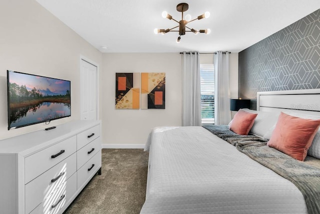 bedroom with dark carpet, an accent wall, a chandelier, baseboards, and wallpapered walls