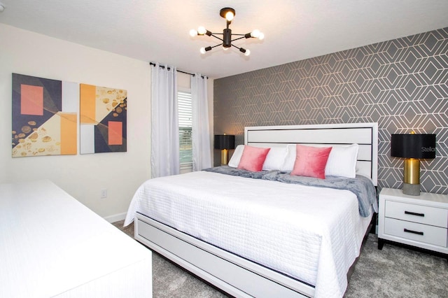 bedroom featuring wallpapered walls, an accent wall, dark carpet, and a chandelier