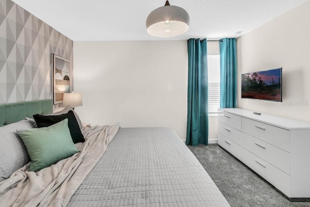 bedroom with baseboards, an accent wall, dark carpet, and wallpapered walls