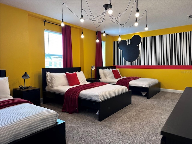 bedroom featuring visible vents, a textured ceiling, baseboards, and carpet flooring