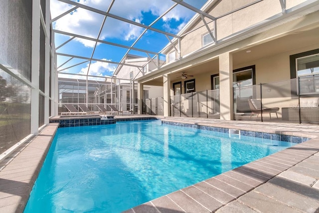 outdoor pool featuring ceiling fan, glass enclosure, and a patio