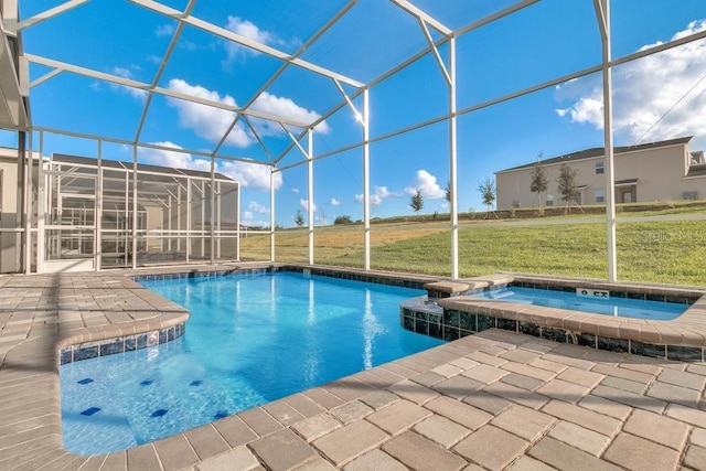 view of swimming pool featuring glass enclosure, a pool with connected hot tub, a patio area, and a lawn