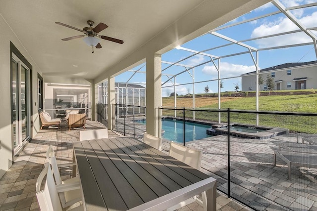 view of patio / terrace featuring glass enclosure, a pool with connected hot tub, and ceiling fan