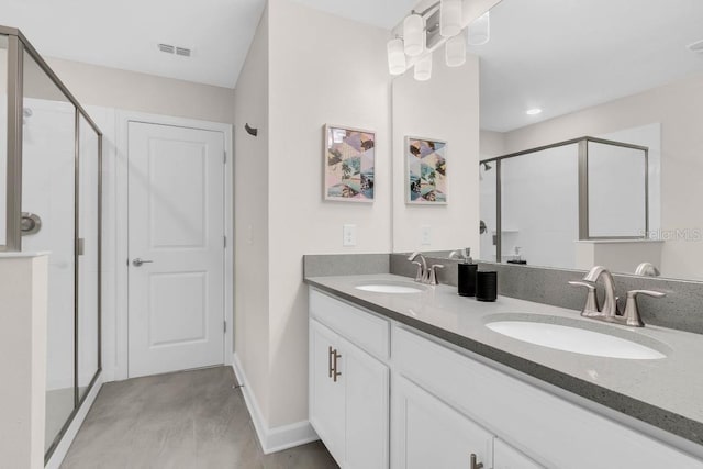 full bath with a stall shower, visible vents, a sink, and double vanity