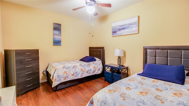 bedroom with dark wood-type flooring and ceiling fan