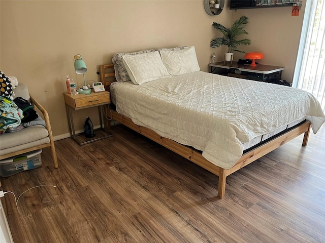 bedroom with dark wood-type flooring and baseboards