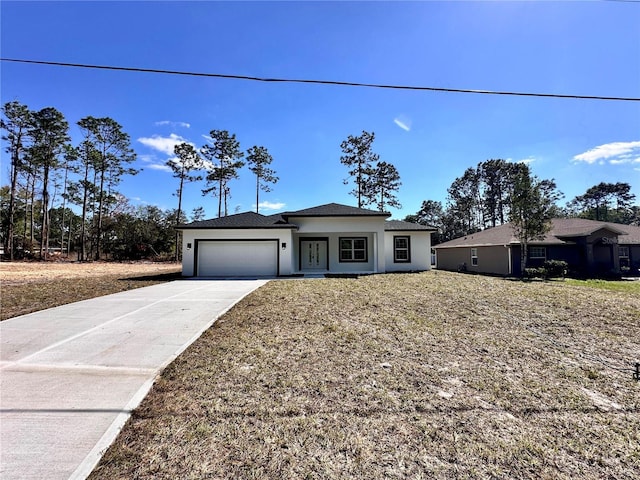 view of front of property with driveway, an attached garage, and stucco siding