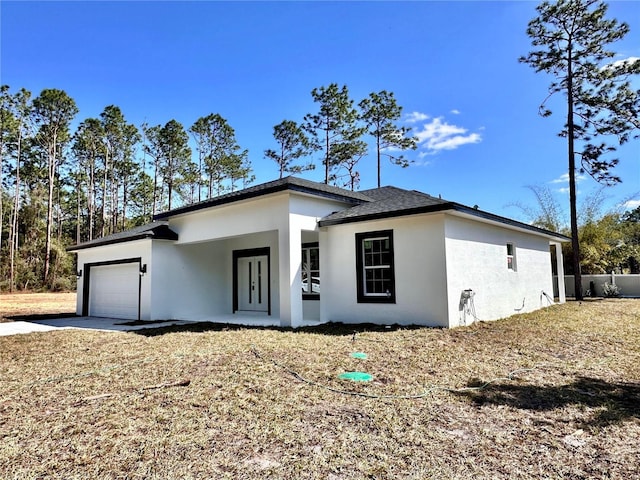 view of front of property featuring a garage, driveway, and stucco siding