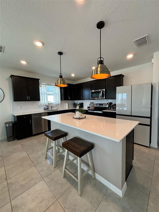 kitchen featuring pendant lighting, stainless steel appliances, and a kitchen island