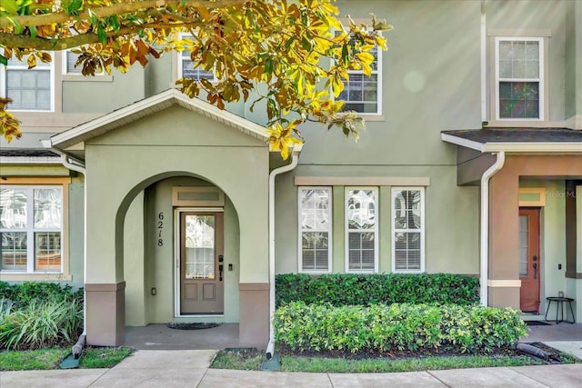 doorway to property featuring stucco siding