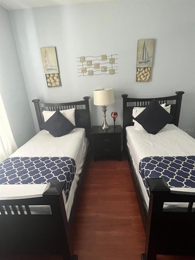 bedroom with dark wood-style flooring