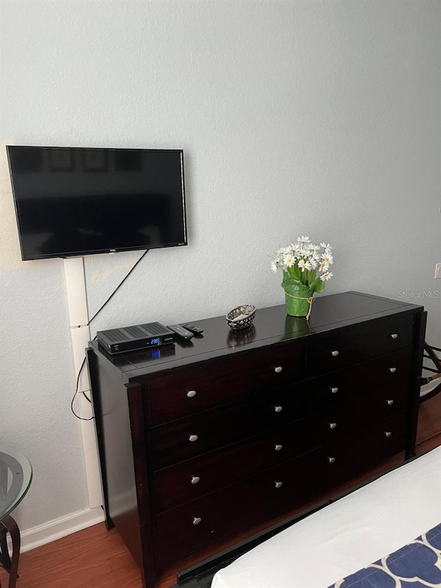 bedroom with baseboards and wood finished floors