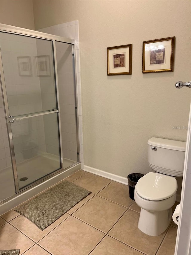 full bathroom with baseboards, a stall shower, toilet, and tile patterned floors